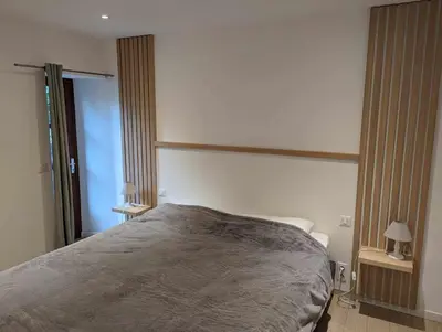a bedroom with a bed and two lamps in it at Appartement proche de Porto-Vecchio in Porto-Vecchio