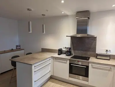 a kitchen with white cabinets and a stove top oven at Appartement proche de Porto-Vecchio in Porto-Vecchio