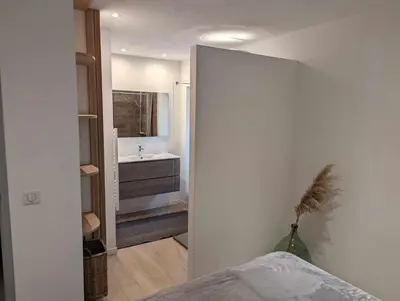 a bedroom with a bathroom with a sink and a mirror at Appartement proche de Porto-Vecchio in Porto-Vecchio