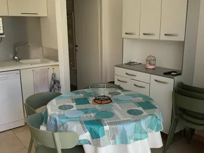 a kitchen with a table with a blue and white table cloth at Appartement T3 en Corse, Marina di Bravone N131 in Linguizzetta