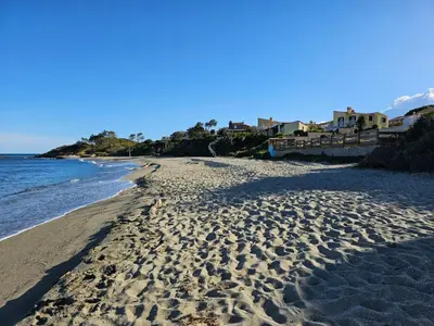 a beach with footprints in the sand and the ocean at Appartement T3 en Corse, Marina di Bravone N131 in Linguizzetta