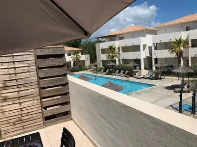 an external view of a hotel with a swimming pool at Appartement T3 en Corse, Marina di Bravone N131 in Linguizzetta