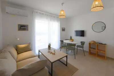 a living room with a couch and a table at marina di bravone 185 vue mer in Linguizzetta