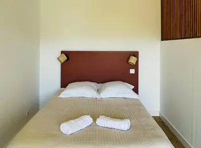 a bedroom with a bed with two pillows on it at Appartement l'orée du bois Ajaccio in Ajaccio
