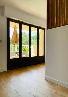 an empty room with sliding glass doors with a patio at Appartement l'orée du bois Ajaccio in Ajaccio