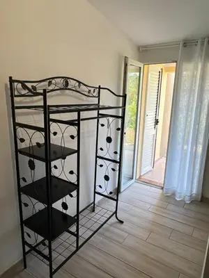 a black rack of wine glasses in a room at Hotel les jardins Sta Giulia avec piscine in Porto-Vecchio