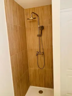 a shower with a shower head in a bathroom at Duplex pour 2 à 6 personnes avec terrasse en plein cœur de la citadelle de Bonifacio in Bonifacio