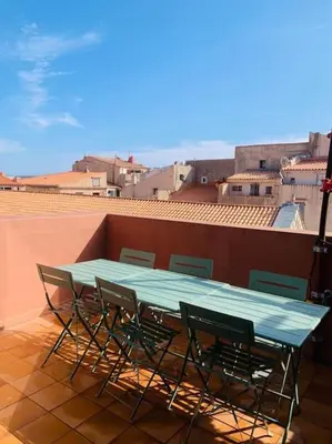 a green table and chairs on a balcony at Duplex pour 2 à 6 personnes avec terrasse en plein cœur de la citadelle de Bonifacio in Bonifacio