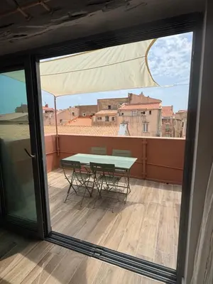 a table on a balcony with a view of the city at Duplex pour 2 à 6 personnes avec terrasse en plein cœur de la citadelle de Bonifacio in Bonifacio