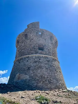 a tall brick tower on top of a hill at Appartement Tour d'Omigna Cargèse in Cargèse