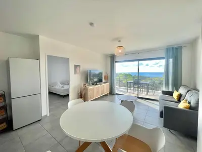 a living room with a white table and a couch at Appartement Tour d'Omigna Cargèse in Cargèse