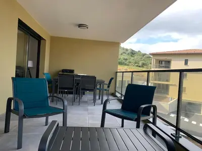 a balcony with chairs and a table on a balcony at Appartement récent, tout confort , vue mer, plage à 5min in Propriano