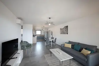 a living room with a couch and a table at Appartement récent, tout confort , vue mer, plage à 5min in Propriano