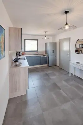 a large kitchen with a large tile floor at Appartement récent, tout confort , vue mer, plage à 5min in Propriano