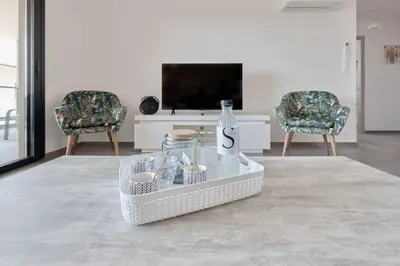 a living room with a bottle and two chairs at Appartement récent, tout confort , vue mer, plage à 5min in Propriano