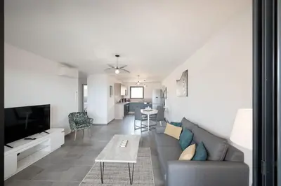 a living room with a couch and a table at Appartement récent, tout confort , vue mer, plage à 5min in Propriano