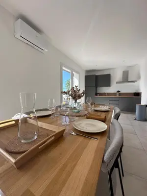 a dining room with a wooden table with wine glasses at Bergerie avec spa vue montagne in San-Nicolao