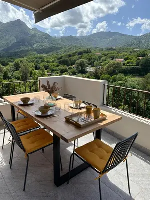 a table and chairs on a balcony with a view at Bergerie avec spa vue montagne in San-Nicolao