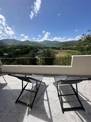 a table and two chairs on a patio with a view at Bergerie avec spa vue montagne in San-Nicolao