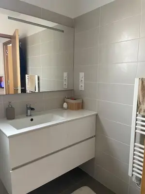 a white bathroom with a sink and a mirror at Appartement T2 avec jardin in Lucciana