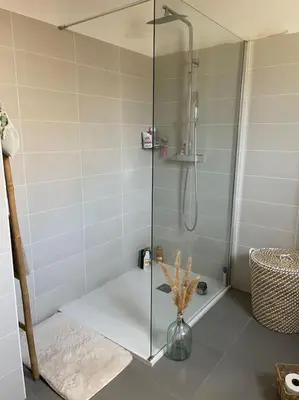 a bathroom with a shower with a vase on the floor at Appartement T2 avec jardin in Lucciana