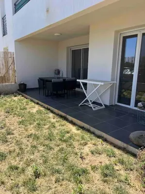 a patio with a table and chairs on a house at Appartement T2 avec jardin in Lucciana