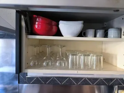 a shelf with glass jars and bowls on it at Maison chaleureuse à Ajaccio avec vue sur le jardin in Ajaccio