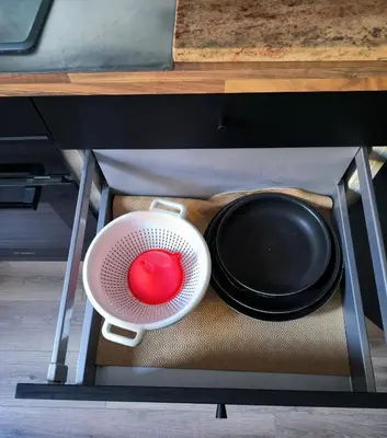 a strainer with a bowl and a plate in a drawer at Maison chaleureuse à Ajaccio avec vue sur le jardin in Ajaccio