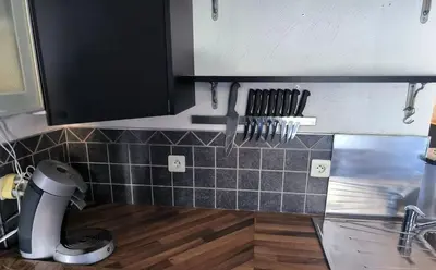 a kitchen with black and white tiles on the wall at Maison chaleureuse à Ajaccio avec vue sur le jardin in Ajaccio