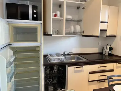 a small kitchen with a sink and a refrigerator at Mini Villa 63 proche plage dans résidence avec piscine à Favone in Sari Solenzara