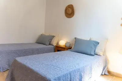 a room with two beds with blue pillows at Villa Tizzano Vue Mer in Sartène