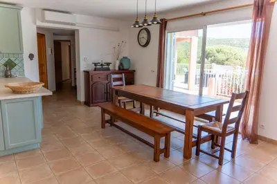 a dining room with a table and chairs and a window at Villa Tizzano Vue Mer in Sartène