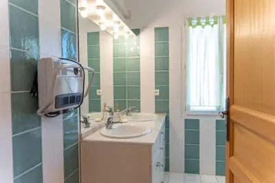 a bathroom with two sinks and a mirror at Villa Tizzano Vue Mer in Sartène