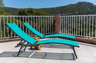 a blue chair sitting on top of a balcony at Villa Tizzano Vue Mer in Sartène