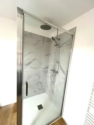 a shower with a glass door in a bathroom at T2 Neuf à 800 m de la plage de Cala Rossa appart n 80 in Lecci