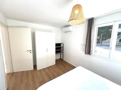 a bedroom with a white refrigerator and a window at T2 Neuf à 800 m de la plage de Cala Rossa appart n 80 in Lecci