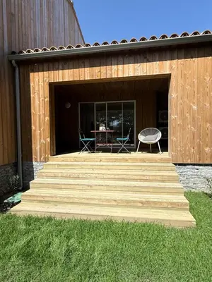 a deck with a table and chairs in a building at T2 Neuf à 800 m de la plage de Cala Rossa appart n 80 in Lecci