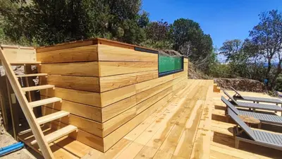 a wooden deck with benches and a wooden wall at 