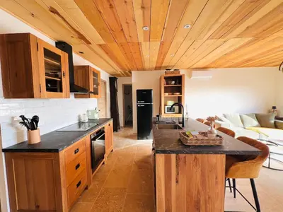 a kitchen with wooden ceilings and a living room at 