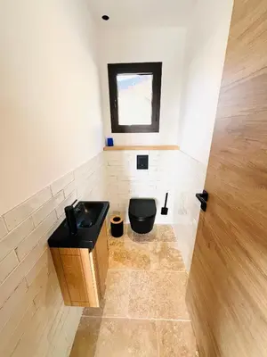 a bathroom with a black toilet and a window at 
