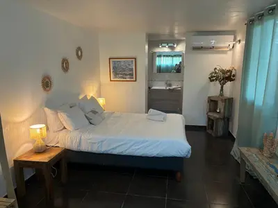 a bedroom with a bed and a table and a mirror at La vie en rose in Coti-Chiavari
