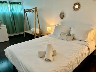 a large white bed with two towels on it at La vie en rose in Coti-Chiavari