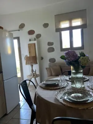 a dining room table with a vase of flowers on it at La Bergerie de l'Alivettu en Corse in Alata