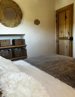 a bedroom with a bed and a mirror on the wall at La Bergerie de l'Alivettu en Corse in Alata