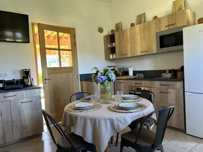 a kitchen with a table with a vase of flowers on it at La Bergerie de l'Alivettu en Corse in Alata