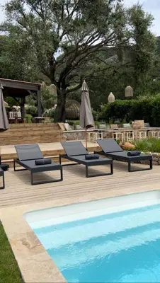 a group of lounge chairs next to a swimming pool at La Bergerie de l'Alivettu en Corse in Alata