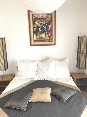 a bed in a room with a picture on the wall at SCI MD in Porto-Vecchio