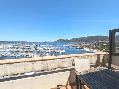 a balcony with a view of a marina with boats at SCI MD in Porto-Vecchio