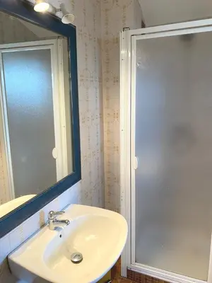 a bathroom with a sink and a shower with a mirror at SCI MD in Porto-Vecchio