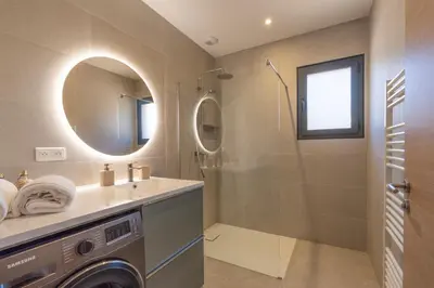 a bathroom with a sink and a washing machine at Casa Omigna in Figari